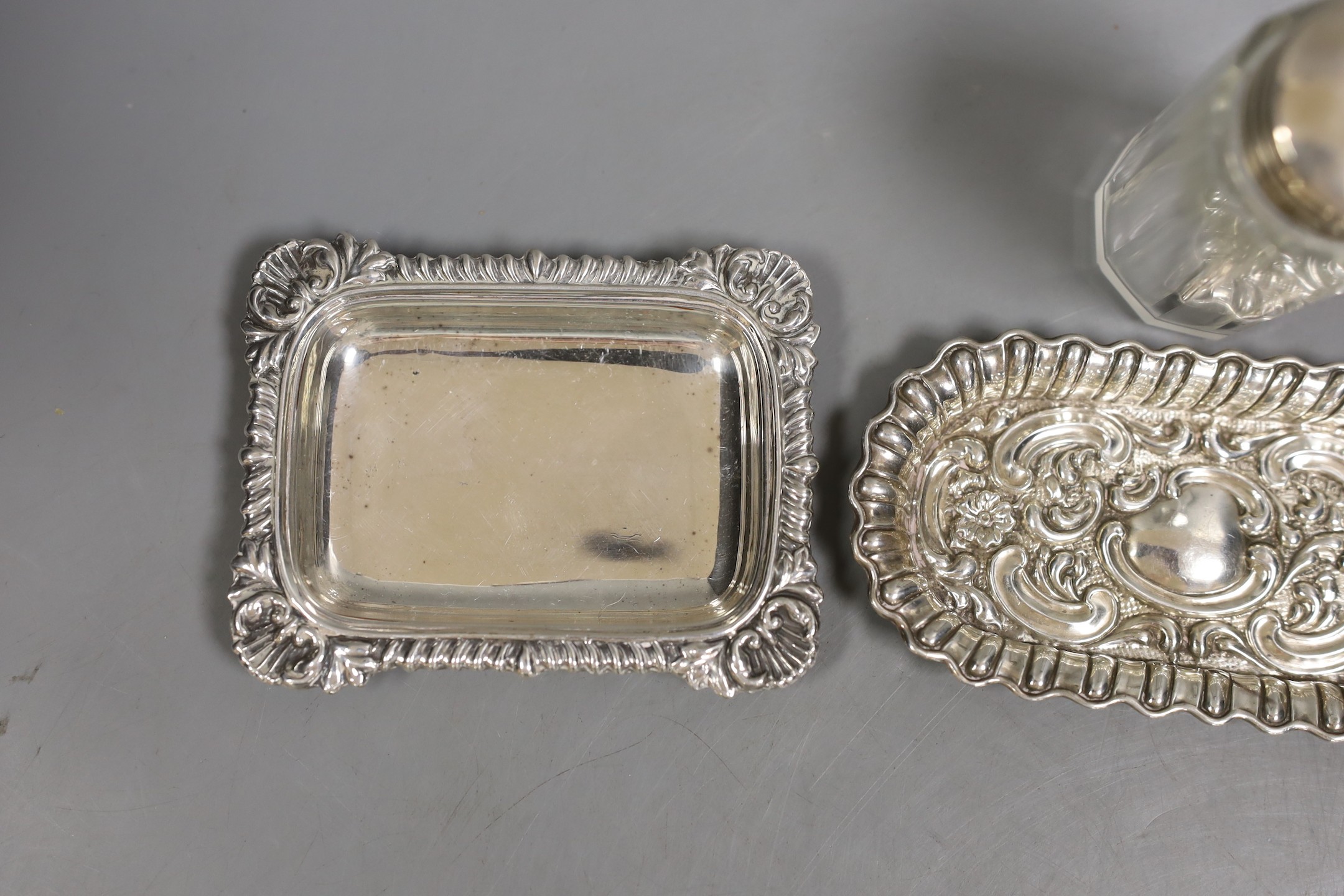 A late Victorian repousse silver 'Mr Punch' pin dish, Saunders & Shepherd, Birmingham, 1894, 10.7cm, one other silver dish, a silver mounted toilet jar and a plated small dish.